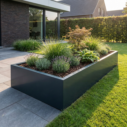 Grote rechthoekige donkergrijze plantenbak gevuld met lavendel en siergrassen op een modern terras in een tuin.